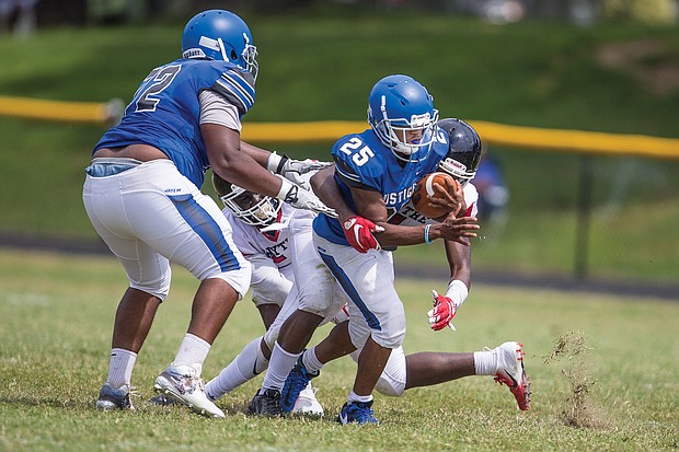 John Marshall High School’s Kevon Dark agilely slips through the pack to carry the ball down the field during last Saturday’s victory over George Wythe High School.