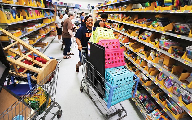 Huguenot High School teacher Catrina Cheeks happily fills her shopping cart with school supplies Wednesday at a Walmart store in South Side. She was among an estimated 200 teachers from Huguenot, Elkhardt-Thompson Middle and Westover Hills Elementary schools surprised with a $200 shopping spree at the Sheila Lane store.  