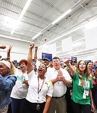Huguenot High School Principal Robert “Rob” Gilstrap, center, joins in the celebration after teachers from the school learn they each have been awarded a $200 shopping spree. Location: The Walmart store on Sheila Lane, just a short distance from the school at 7945 Forest Hill Ave.   