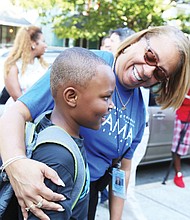 First day welcome: Barack Obama Elementary School Principal Jennifer Moore welcomes 7-year-old Christopher Pleasants to the first day of school Tuesday. Opened in 1922, the Fendall Avenue school had been named for a Confederate general. (Regina H. Boone/Richmond Free Press)