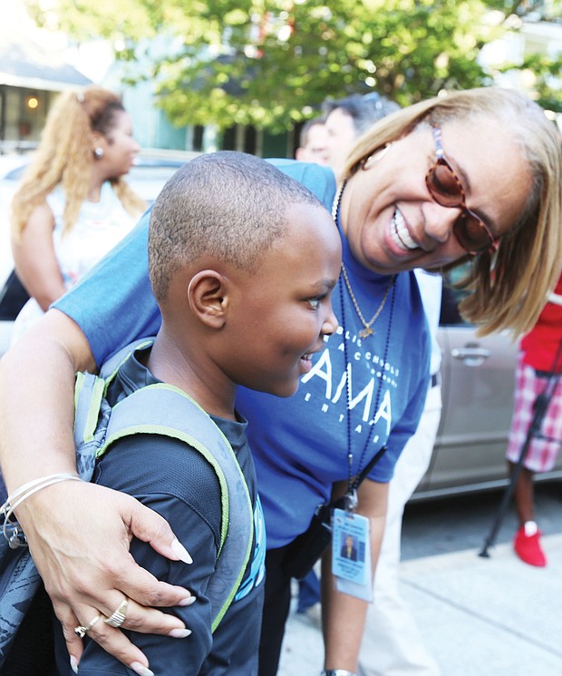 First day welcome: Barack Obama Elementary School Principal Jennifer Moore welcomes 7-year-old Christopher Pleasants to the first day of school Tuesday. Opened in 1922, the Fendall Avenue school had been named for a Confederate general. (Regina H. Boone/Richmond Free Press)