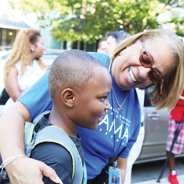 First day welcome: Barack Obama Elementary School Principal Jennifer Moore welcomes 7-year-old Christopher Pleasants to the first day of school Tuesday. Opened in 1922, the Fendall Avenue school had been named for a Confederate general. (Regina H. Boone/Richmond Free Press)