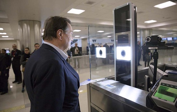 As part of CBP’s one-to-one biometric facial recognition testing on inbound, international flights, a traveler has his photo taken and compared against his passport photo to confirm his identity at Dulles Airport. Photo by Glenn Fawcett