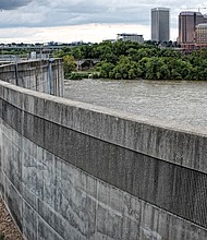 Richmond’s 24-year-old floodwall seeks to guard low-lying areas of the city when the James River is at flood stage. This is a view of the 2,000-foot wall on South Side looking north toward Downtown. But as Richmond has learned, the floodwall can create flooding behind it when heavy rainfall dousing the city is unable to escape into the river, which happened during Tropical Storm Gaston in 2004. To reduce that problem, the city in June tested the floodwall gates to ensure that they can be opened to let water out. (Sandra Sellars/Richmond Free Press)