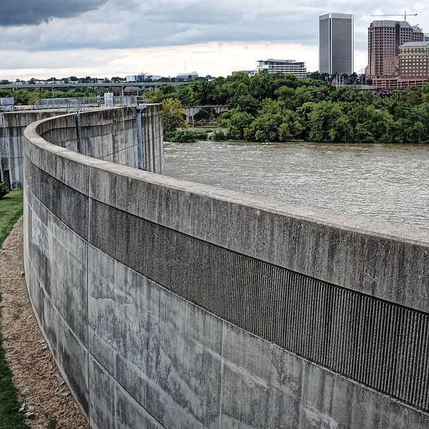Richmond’s 24-year-old floodwall seeks to guard low-lying areas of the city when the James River is at flood stage. This is a view of the 2,000-foot wall on South Side looking north toward Downtown. But as Richmond has learned, the floodwall can create flooding behind it when heavy rainfall dousing the city is unable to escape into the river, which happened during Tropical Storm Gaston in 2004. To reduce that problem, the city in June tested the floodwall gates to ensure that they can be opened to let water out. (Sandra Sellars/Richmond Free Press)