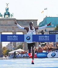 After sprinting through the Brandenburg Gate, Eliud Kipchoge crosses the finish line to break the tape and a world record Sunday at the Berlin Marathon. He is the first person ever to finish a 26.6-mile marathon in less than 2 hours and 2 minutes.