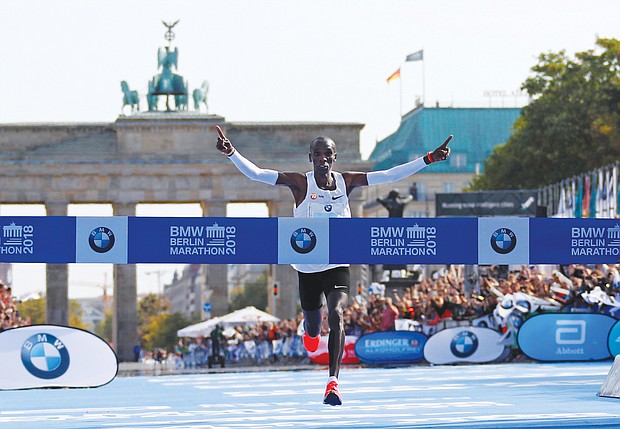 After sprinting through the Brandenburg Gate, Eliud Kipchoge crosses the finish line to break the tape and a world record Sunday at the Berlin Marathon. He is the first person ever to finish a 26.6-mile marathon in less than 2 hours and 2 minutes.