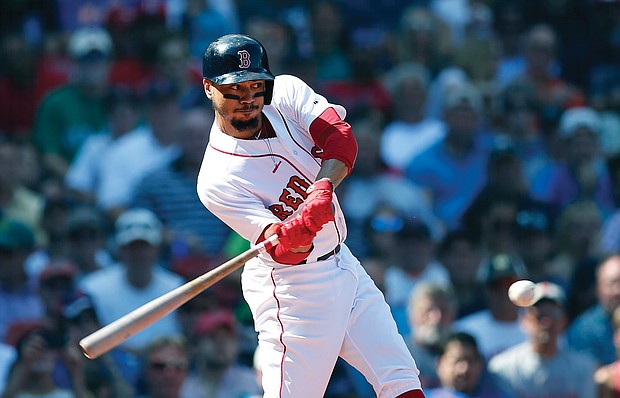 Mookie Betts of the Boston Red Sox hits a sacrifice fly to bring in a run during last Sunday’s game against the New York Mets in Boston.