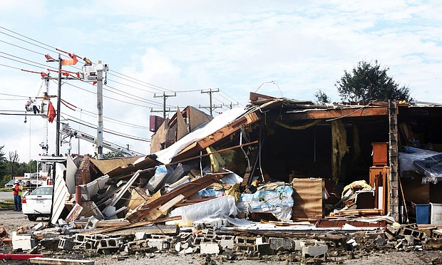 A crew works to restore power to businesses located near a store in Chesterfield County that was wrecked Monday when a tornado struck. The furniture store on Hull Street Road and Speeks Drive partially collapsed in the storm.