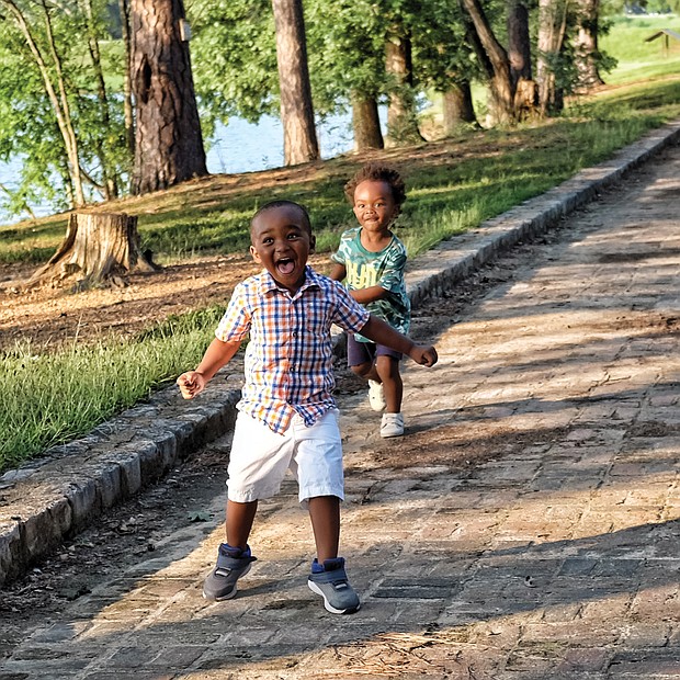 Two-year-old cousins Khamryn Tyler, left, and Xavier Taylor enjoy the sunshine and running along a brick walkway at Shields Lake in Byrd Park on Wednesday during an outing with their moms, Benneka Tucker and Leesa Taylor, and their grandfather, Emanuel Crawford. Area residents welcomed the nice weather after the string of overcast days and sheets of rain associated with the hurricane.
