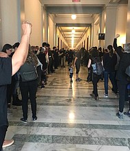 Protesters gather outside the offices of Senators who are in control of the vote to approve potential Supreme Court Judge Brett Kavanuagh. A group of them raise their fists in solidarity to Brett Kavanaugh's victims.