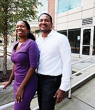 Husband and wife team Arvat McClaine and Harry Watkins stand outside the Vistas on the James condominium complex in Shockoe Bottom, where they are opening Bateau, A Coffee and Wine Experience.