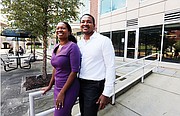 Husband and wife team Arvat McClaine and Harry Watkins stand outside the Vistas on the James condominium complex in Shockoe Bottom, where they are opening Bateau, A Coffee and Wine Experience.