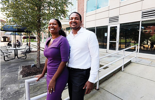 Husband and wife team Arvat McClaine and Harry Watkins stand outside the Vistas on the James condominium complex in Shockoe Bottom, where they are opening Bateau, A Coffee and Wine Experience.