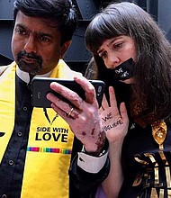 Wil Sands grabs a first-hand image of protesters intently watching Dr. Christine Blasey Ford's testimony in the Hart Senate Building. Powerful phrases like, "We Believe," and "Side With Love," are present as demonstrators make their case for sexual assault victims.