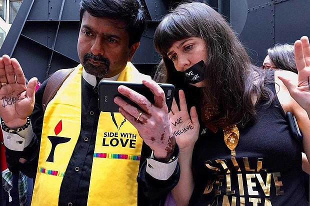 Wil Sands grabs a first-hand image of protesters intently watching Dr. Christine Blasey Ford's testimony in the Hart Senate Building. Powerful phrases like, "We Believe," and "Side With Love," are present as demonstrators make their case for sexual assault victims.