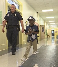 BMPD Officer Ronald Saladin patrols halls with first grade helper.