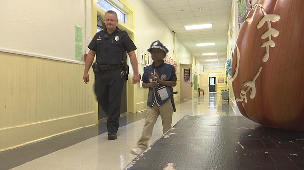BMPD Officer Ronald Saladin patrols halls with first grade helper.
