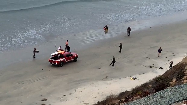 	John Robbins shot several videos showing shark attack victim pulled ashore by rescuers and being helped by emergency personnel at Beacon's Beach in Encinitas, California