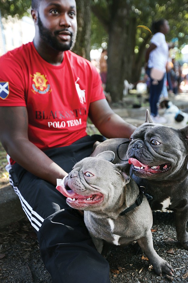 Paws pause: Marcus Perry and his two French bulldogs, Hugo and Keiko, take a break at the inaugural Richmond Dog Festival last Saturday at 17th Street Market in Shockoe Bottom. The festival, benefiting the Enrichmond Foundation, brought together dog lovers and their dogs for music, demonstrations, a pet fashion show, food, music and a bevy of vendors who serve Richmond’s pet community, including dog sitters, trainers, rescue leagues and makers of dog treats. (Regina H. Boone/Richmond Free Press)