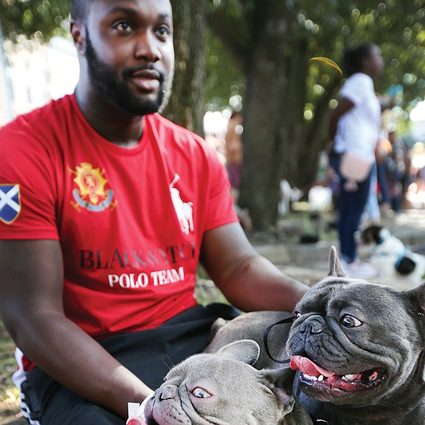 Paws pause: Marcus Perry and his two French bulldogs, Hugo and Keiko, take a break at the inaugural Richmond Dog Festival last Saturday at 17th Street Market in Shockoe Bottom. The festival, benefiting the Enrichmond Foundation, brought together dog lovers and their dogs for music, demonstrations, a pet fashion show, food, music and a bevy of vendors who serve Richmond’s pet community, including dog sitters, trainers, rescue leagues and makers of dog treats. (Regina H. Boone/Richmond Free Press)