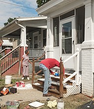 Volunteers Jeff Boisseau, left, and Chris Barrett put a fresh coat of paint on the Letcher Avenue home of Bernice Clack, center, during last Sunday’s “Day of Service,” sponsored by an alliance of churches and other organizations to assist Highland Park residents. 