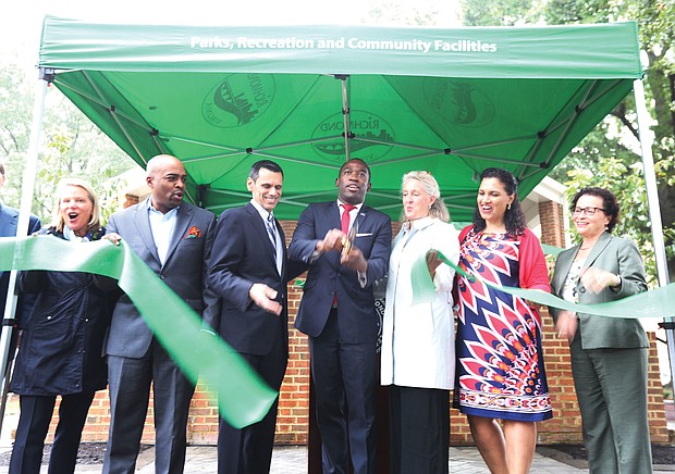 Mayor Levar M. Stoney, center, cuts the ribbon to reopen Monroe Park on Sept. 27. He is flanked by VCU President Michael Rao and Alice M. Massie, president of the park’s new governing body, the Monroe Park Conservancy, and other dignitaries. The nearly 8-acre space was Richmond’s first public park when the city acquired the land in 1851. The reopening will allow churches and other groups to resume serving meals to the homeless on weekends. The Monroe Park Conservancy has a 30-year lease with the city to operate and manage the park in cooperation with the city’s Department of Parks, Recreation and Community Facilities. (Regina H. Boone/Richmond Free Press)