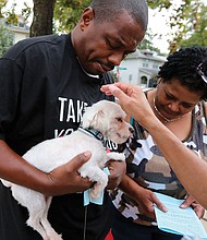 Blessing of the animals: The Rev. Phoebe A. Roaf, rector of St. Philip’s Episcopal Church, places her hand in prayer on Renz, the 3-year-old pet of Bernard Brown and Patricia Smith, during last Saturday’s annual Blessing of the Animals service at the North Side church. Each pet received a St. Francis medal and treats. The services typically are held on or around the Oct. 4 Feast Day for St. Francis of Assisi, the patron saint of animals. (Regina H. Boone/Richmond Free Press)