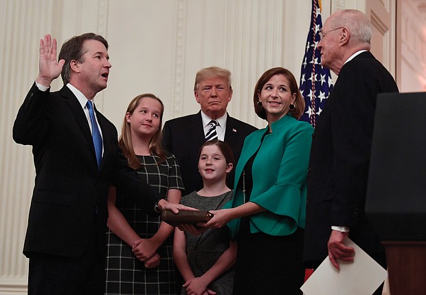 With President Trump watching, Justice Brett Kavanaugh is sworn in as a U.S. Supreme Court associate justice Monday during a televised ceremony in the East Room at the White House. Retired Justice Anthony Kennedy, who Justice Kavanaugh replaces on the nation’s high court, performed the ceremony. With the new justice are his wife, Ashley, and daughters Margaret, left, and Liza.