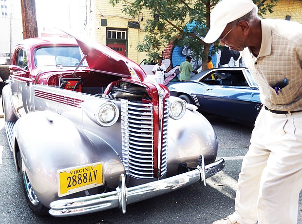 Robert Ford Sr. of Henrico County takes a closer look at a 1938 Buick 350 TP owned by Charles Muse of Richmond. The vintage auto was on display with others shown at the 2nd Street Festival by the Richmond Metropolitan Antique Car Club. (Regina H. Boone/Richmond Free Press)