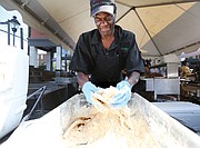 David Senegal of Croaker’s Spot restaurant batters some fish before frying it for the tasty fish boats featured on the menu at the 2nd Street Festival. (Regina H. Boone/Richmond Free Press)