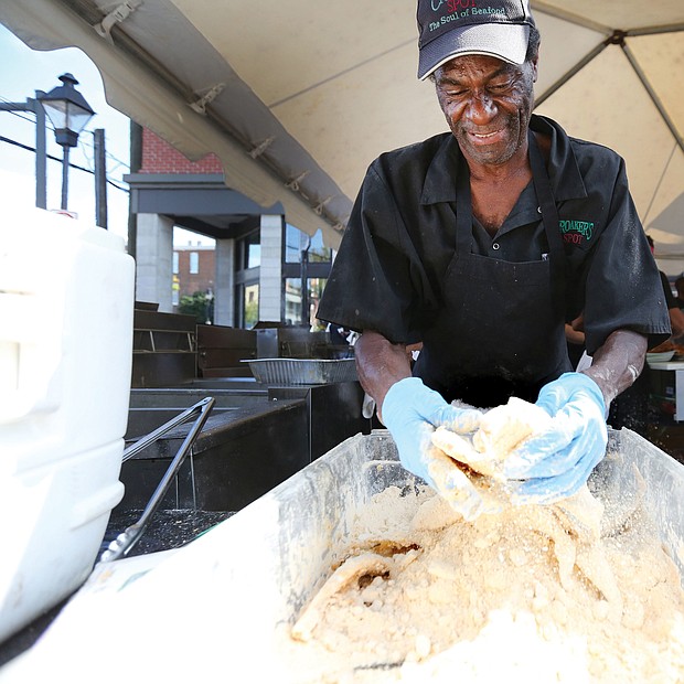 David Senegal of Croaker’s Spot restaurant batters some fish before frying it for the tasty fish boats featured on the menu at the 2nd Street Festival. (Regina H. Boone/Richmond Free Press)