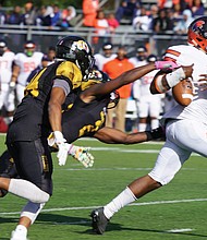 Virginia State University quarterback Cordelral Cook tries to hang onto the ball while under pressure from the Bowie State University defense at last Saturday’s game in Maryland. The VSU Trojans fell to the Bulldogs 20-15.