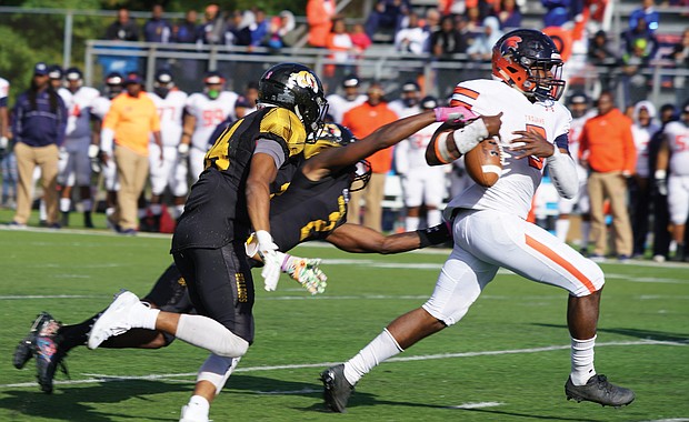 Virginia State University quarterback Cordelral Cook tries to hang onto the ball while under pressure from the Bowie State University defense at last Saturday’s game in Maryland. The VSU Trojans fell to the Bulldogs 20-15.