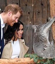 Prince Harry and his wife, Meghan, the expecting Duchess of Sussex, meet Ruby, a mother koala, during their visit Tuesday to Taronga Zoo in Sydney, Australia. The koala recently gave birth to two joeys that have been named for the royal couple.