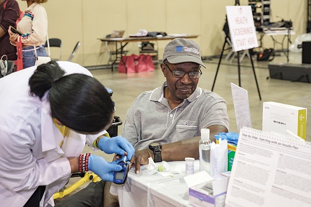 Heart talk: Ronald Bowie of Prince George has his blood sugar level checked by Kimberly Ketter, a nurse practitioner with Case Management Associates of Petersburg at the Spirit of the Heart Health Initiative at the Greater Richmond Convention Center. (Ava Reaves)