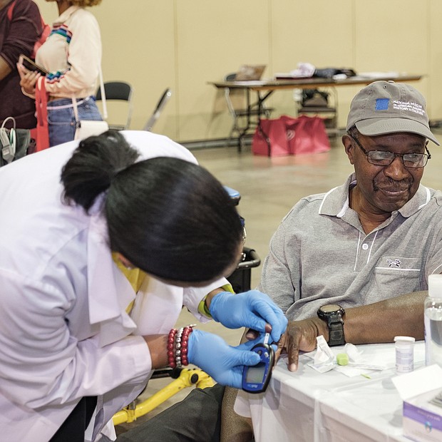Heart talk: Ronald Bowie of Prince George has his blood sugar level checked by Kimberly Ketter, a nurse practitioner with Case Management Associates of Petersburg at the Spirit of the Heart Health Initiative at the Greater Richmond Convention Center. (Ava Reaves)