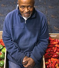 Charles E. Fitzgerald shows off a bounty of fresh peppers that he and other Atlee Church volunteers had ready for distribution at the Moss Side Avenue church last Saturday.