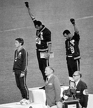 Athletes Smith, center, and Carlos give the Black Power Salute during the medal ceremony at the 1968 Summer Olympics in Mexico City. Smith finished first in the 200-meter sprint, while Peter Norman of Australia finished second and Carlos, third. All three wore human rights patches on their jackets.