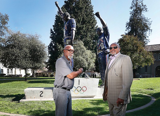John Carlos, left, and Tommie Smith stand on Oct. 17 in front of the statue on the campus of their alma mater, San Jose State University, that honors their protest 50 years ago at the Mexico City Olympics.