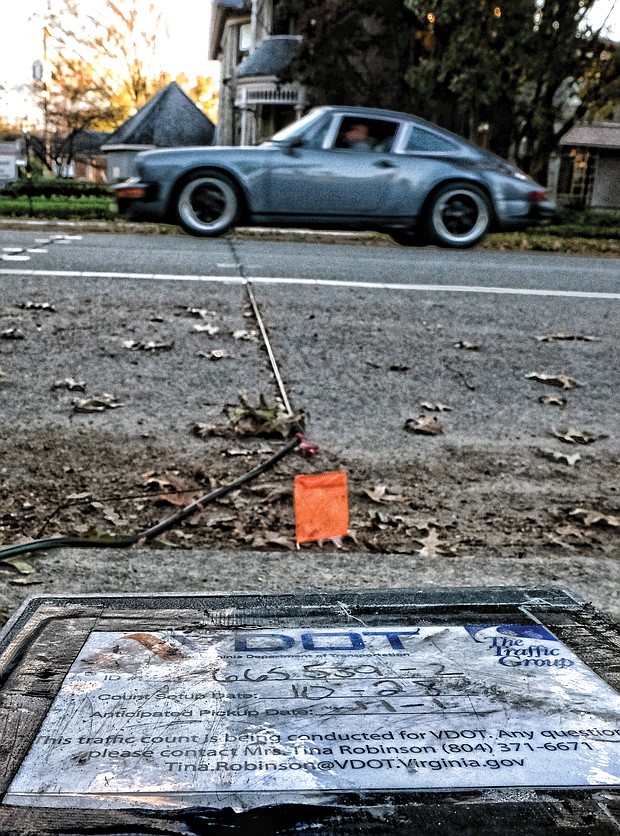 By driving over the black rubber tubing across the roadway, this car adds to the count of vehicles using this street on Monday in Richmond’s Museum District. Location: 2900 block of Grove Avenue. Collecting accurate data on the number of vehicles using a roadway is part of the work of the Virginia Department of Transportation, which regularly sets out counters and the connecting tubing on streets and roads across the state. (Sandra Sellars/Richmond Free Press)