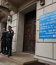 NYPD officers stand guard at the door of the Union Temple of Brooklyn on November 2, 2018 in New York City. - New York police were investigating anti-Semitic graffiti found inside a Brooklyn synagogue that forced the cancellation of a political event less than a week after the worst anti-Semitic attack in modern US history.