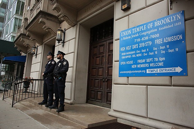 NYPD officers stand guard at the door of the Union Temple of Brooklyn on November 2, 2018 in New York City. - New York police were investigating anti-Semitic graffiti found inside a Brooklyn synagogue that forced the cancellation of a political event less than a week after the worst anti-Semitic attack in modern US history.