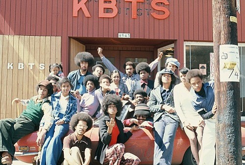 Volunteers pose in front of KBTS community radio station on N Knott street. The soul radio station was also a venue for community events and talk shows. 1970s.