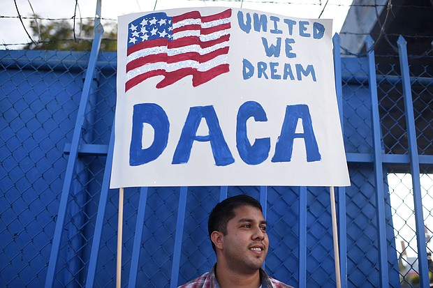 DACA recipient and appliance repair business owner Erick Marquez holds a sign during a protest in support of DACA, September 10, 2017, in Los Angeles.