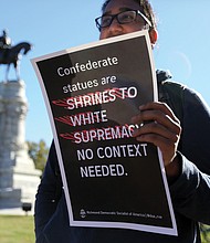 Point, counterpoint: The rally was the fifth held in the city since 2017 by the Confederate groups to show support for keeping the Confederate monuments. Counterprotesters, including this young man who did not want to be identified, held signs expressing their opposing position. Dozens of law enforcement officers were on hand to monitor events. (Regina H. Boone/Richmond Free Press)
