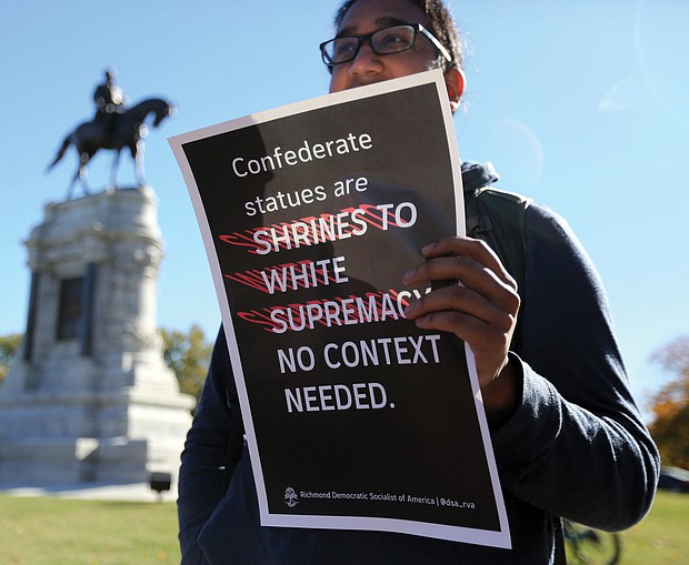 Point, counterpoint: The rally was the fifth held in the city since 2017 by the Confederate groups to show support for keeping the Confederate monuments. Counterprotesters, including this young man who did not want to be identified, held signs expressing their opposing position. Dozens of law enforcement officers were on hand to monitor events. (Regina H. Boone/Richmond Free Press)