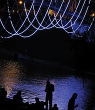 Ropes of lights add an artistic touch to this pedestrian bridge on the city’s riverfront. The lines that seem to hang in the air are attached to the bottom of the pedestrian bridge that crosses the Kanawha Canal and links Tredegar Street at 7th Street to Brown’s Island.  (Sandra Sellars/Richmond Free Press)