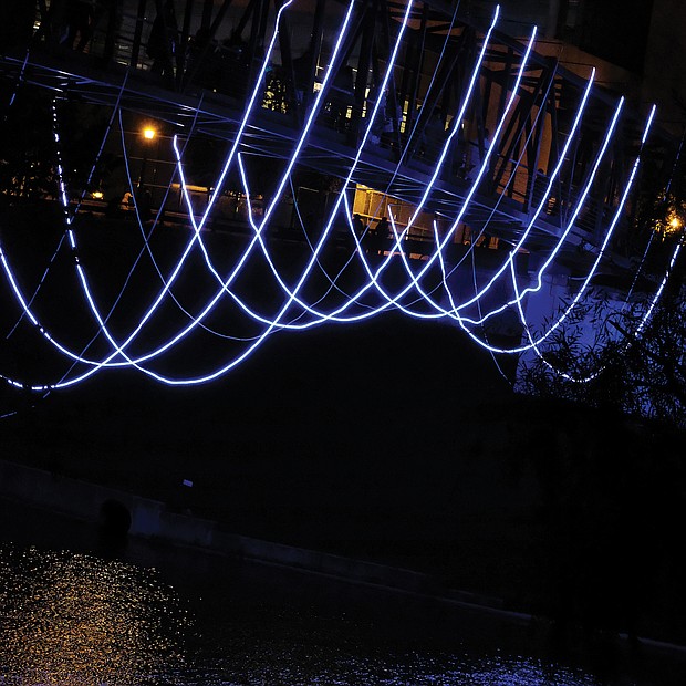 Ropes of lights add an artistic touch to this pedestrian bridge on the city’s riverfront. The lines that seem to hang in the air are attached to the bottom of the pedestrian bridge that crosses the Kanawha Canal and links Tredegar Street at 7th Street to Brown’s Island.  (Sandra Sellars/Richmond Free Press)