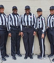 The all-female officials team, plus referee Elbert Lassiter (far right) and umpire Leonard VanHoose (far left),